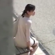 A Japanese woman sits on a bench at a public beach, discreetly takes a shit off the side of the bench, and then wipes her ass. About 3 minutes.